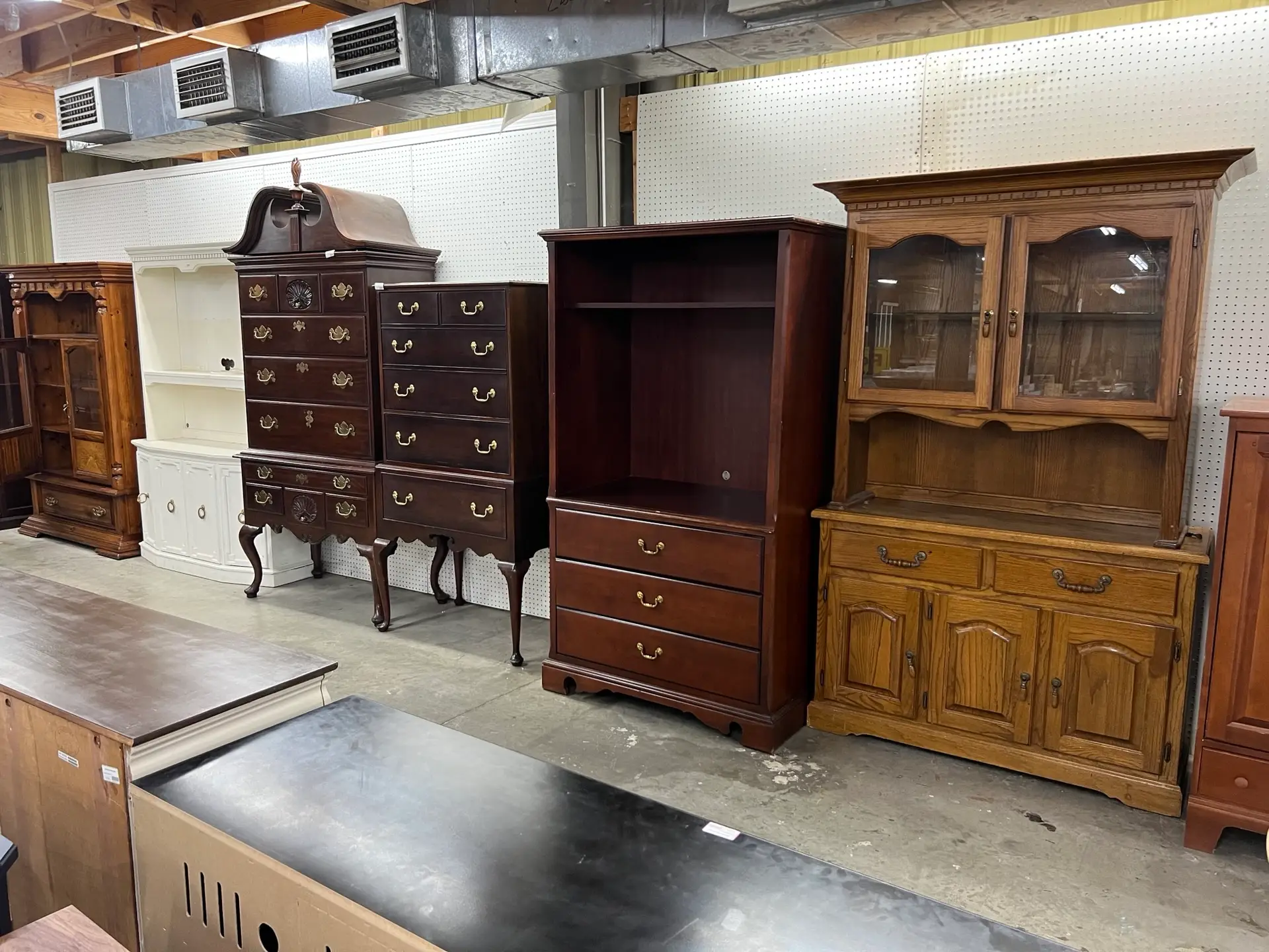 Vintage wooden cabinets and antique furniture display at The Re-Store Warehouse in Fayetteville, NC