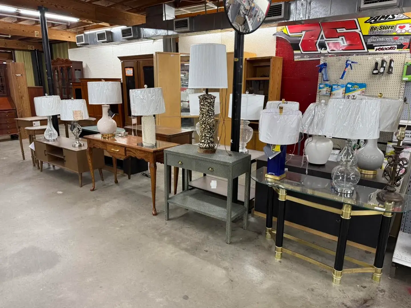 Selection of table lamps with white lampshades displayed on entryway console tables and desks at Re-Store Warehouse