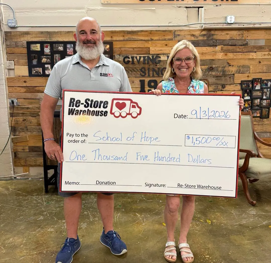 Re-Store Warehouse presenting a $1,500 community donation check to School of Hope in Fayetteville, NC